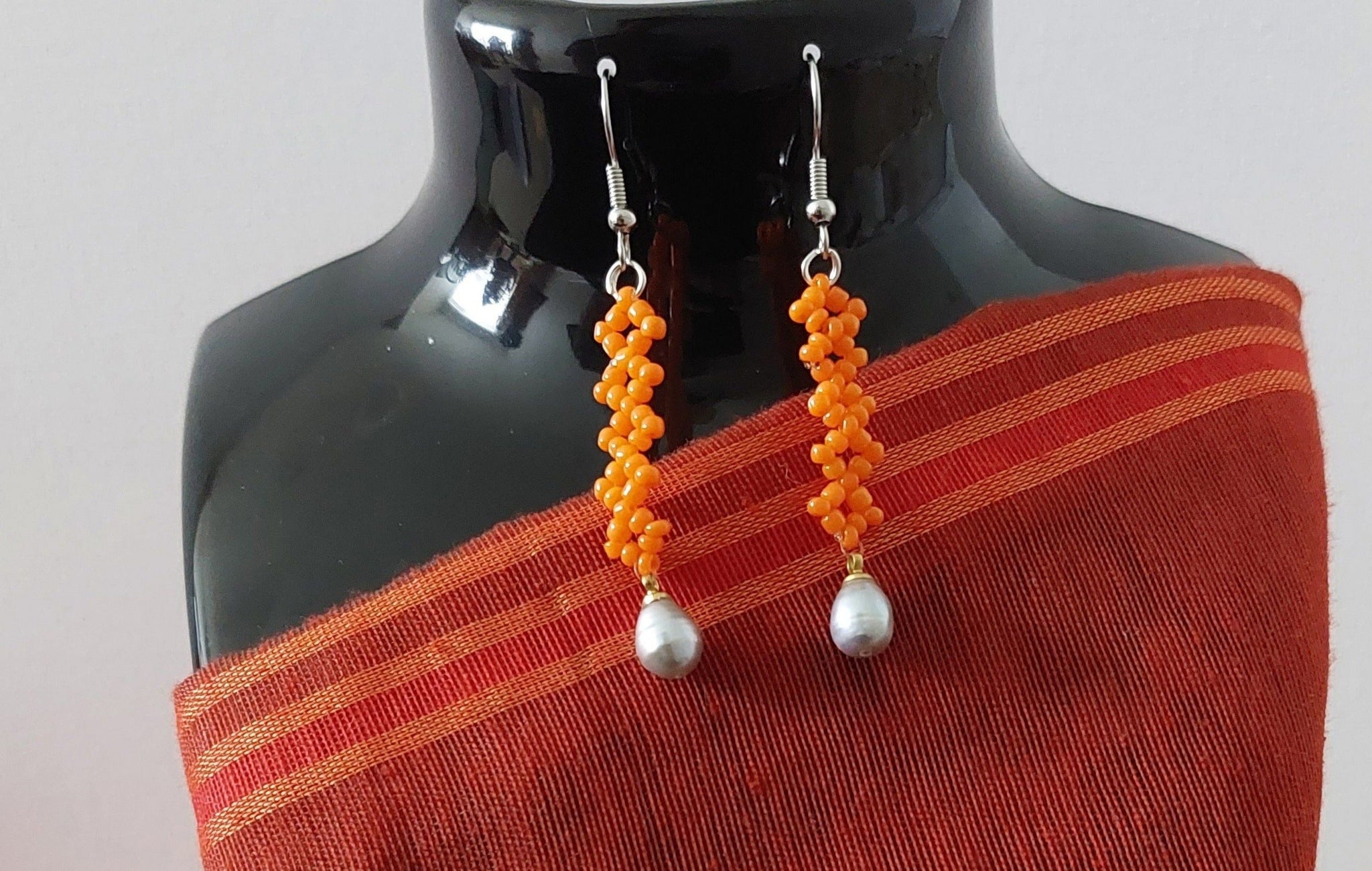 Long simple orange earring with gray dangling teardrop pearl